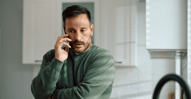 Concerned man on the phone in kitchen